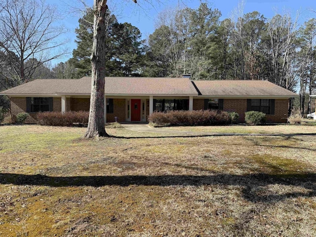 ranch-style house featuring a front lawn and brick siding