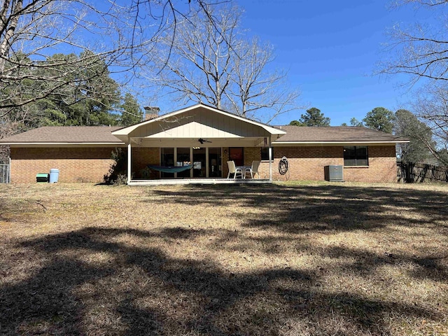 back of property featuring brick siding, ceiling fan, cooling unit, a chimney, and a patio area