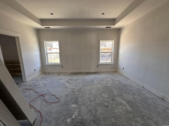 spare room featuring baseboards, stairs, and a tray ceiling