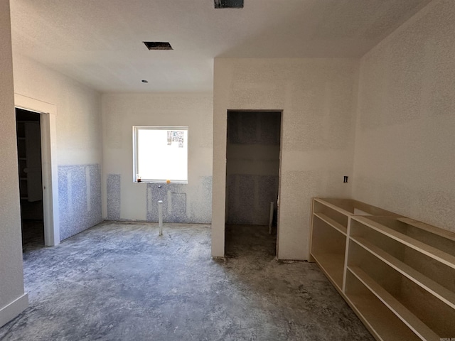 unfurnished bedroom featuring unfinished concrete floors