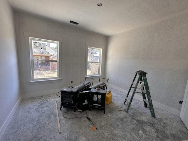 office area with baseboards, carpet, and a wood stove