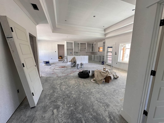 living room with a tray ceiling and ornamental molding