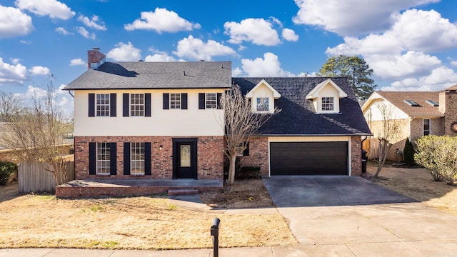 view of front of home with brick siding, concrete driveway, and fence