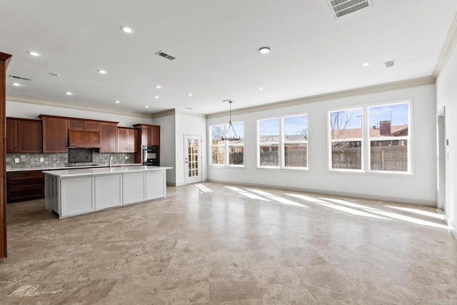 kitchen featuring decorative backsplash, a healthy amount of sunlight, open floor plan, and oven