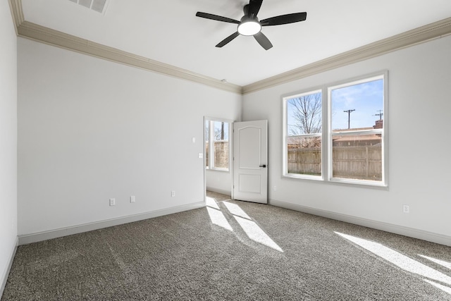 carpeted spare room with ceiling fan, crown molding, and baseboards