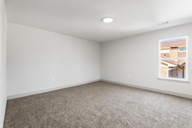 carpeted empty room featuring visible vents and baseboards