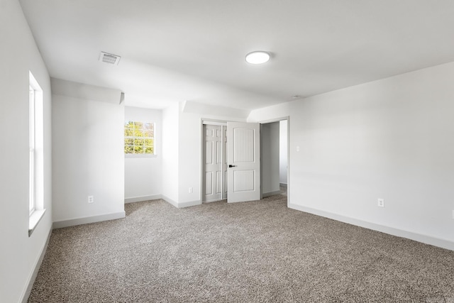 unfurnished bedroom featuring a closet, visible vents, baseboards, and carpet floors