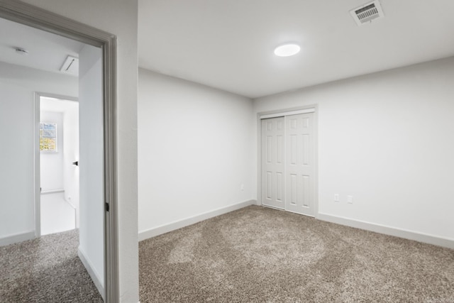 empty room featuring carpet, visible vents, and baseboards