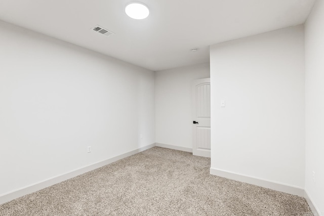 spare room with visible vents, light carpet, and baseboards