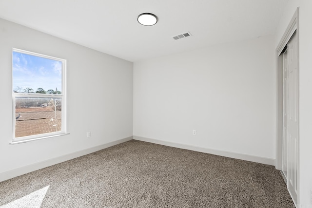 unfurnished bedroom featuring carpet flooring, baseboards, visible vents, and a closet