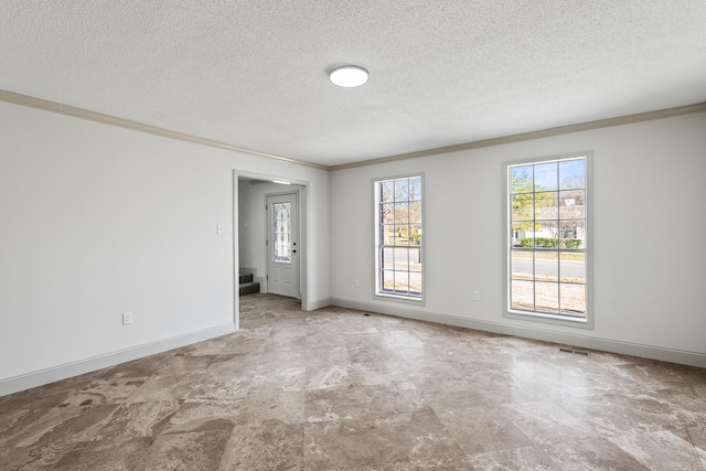 unfurnished room with a textured ceiling, baseboards, visible vents, and ornamental molding