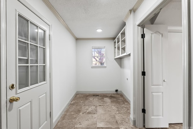 washroom with stone finish flooring, a textured ceiling, crown molding, and baseboards