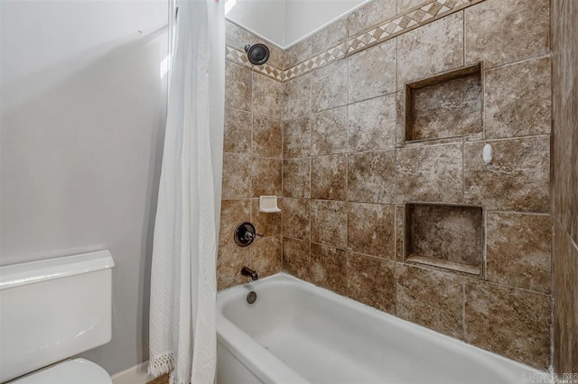 bathroom with toilet and shower / bath combo with shower curtain