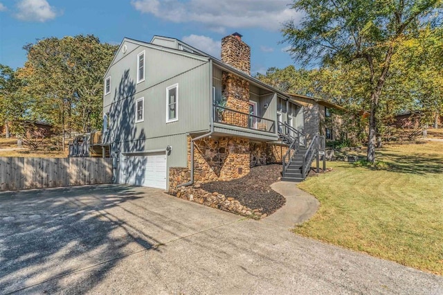 view of front of house with driveway, a front lawn, stone siding, stairway, and a chimney