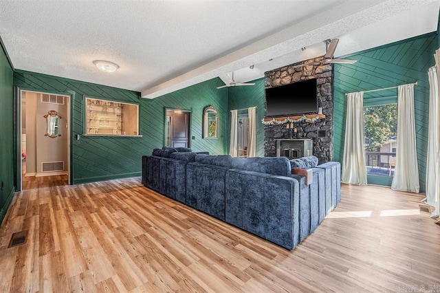 living room with visible vents, a textured ceiling, and wood finished floors