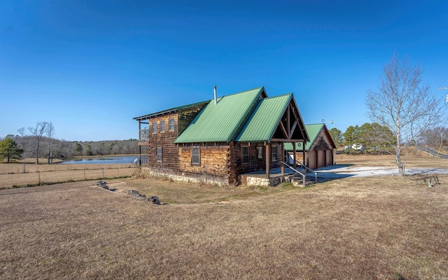 view of side of home featuring metal roof, a water view, and log exterior