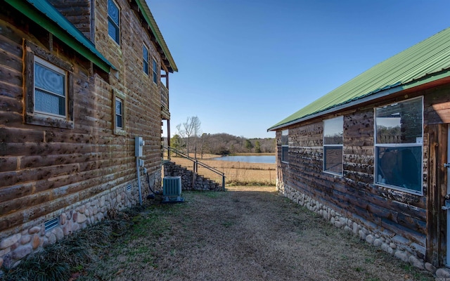 view of yard featuring central AC unit and a water view