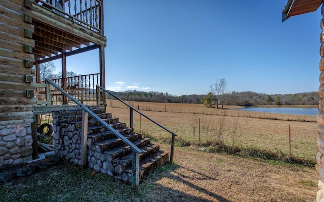 view of yard with a water view and stairs