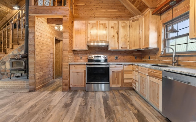 kitchen featuring light brown cabinets, under cabinet range hood, appliances with stainless steel finishes, wood finished floors, and a sink