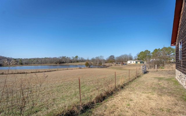 view of yard with a water view and fence