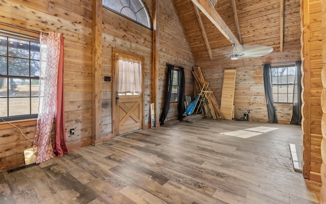 spare room with wood finished floors, high vaulted ceiling, wood ceiling, wood walls, and beamed ceiling