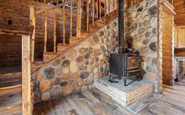 interior details featuring stainless steel electric range, a wood stove, and wood finished floors