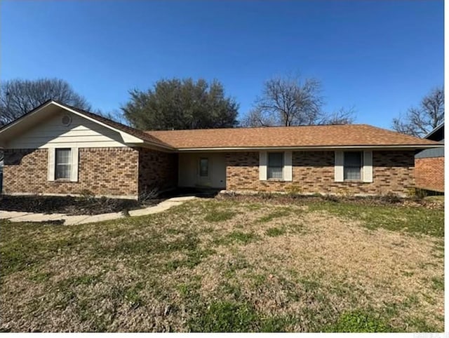 single story home featuring brick siding and a front yard