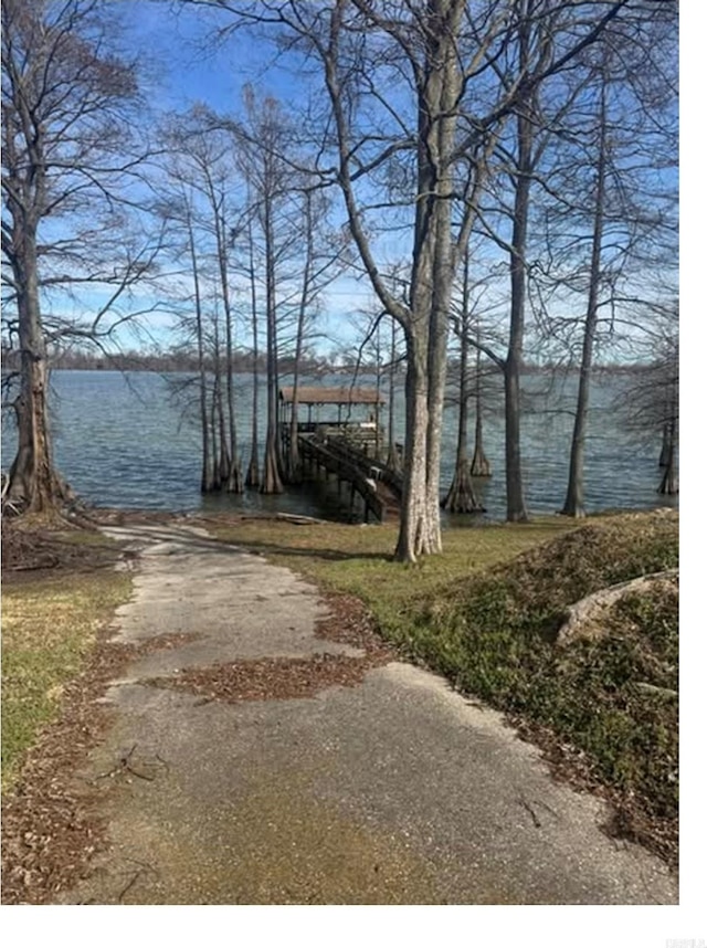 exterior space featuring aphalt driveway, a water view, and a boat dock