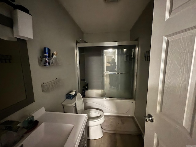 full bathroom featuring enclosed tub / shower combo, toilet, wood finished floors, and vanity