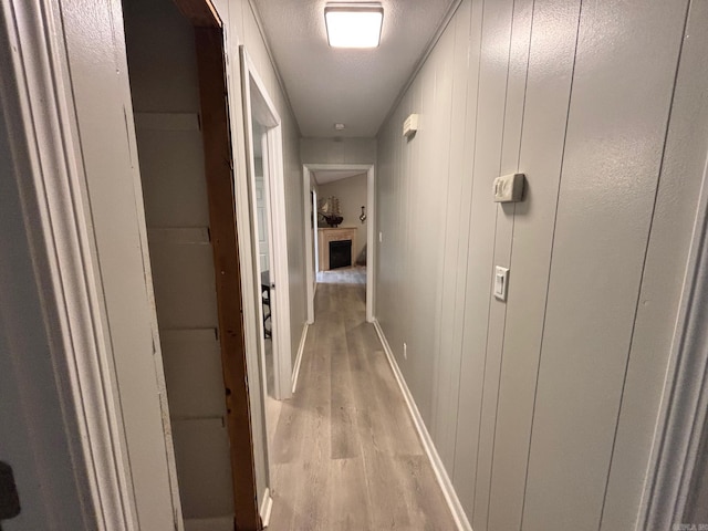 hall with baseboards and light wood-style floors