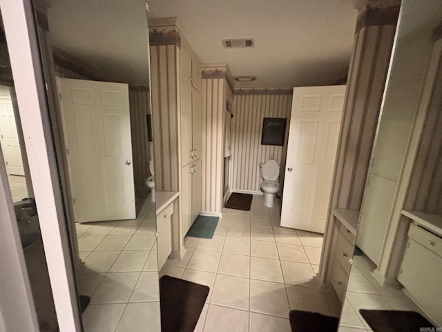 bathroom featuring tile patterned flooring, visible vents, and toilet