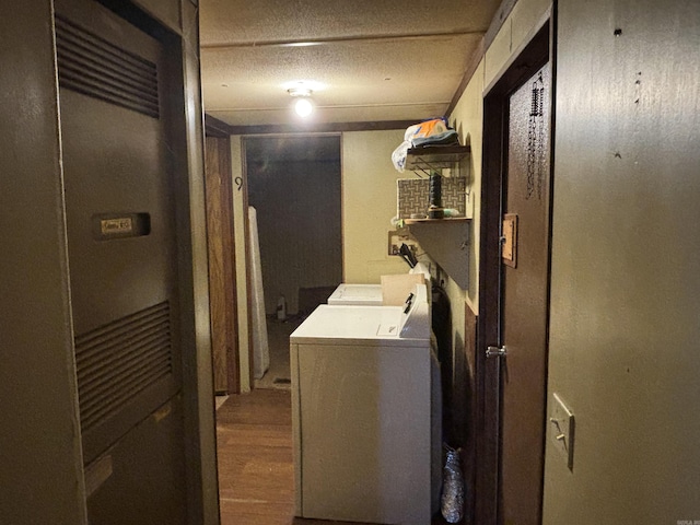 laundry room featuring a textured ceiling, independent washer and dryer, and wood finished floors