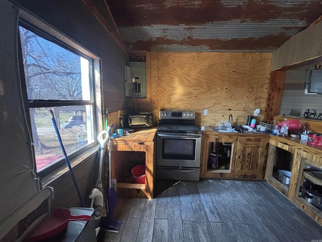 kitchen featuring electric panel, electric range, dark wood-type flooring, and wooden walls