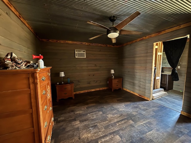 unfurnished bedroom with dark wood-type flooring, a ceiling fan, and wood walls