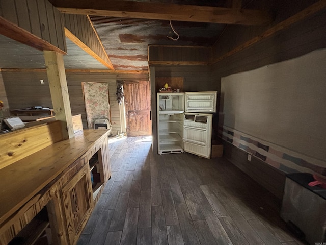 kitchen with dark wood-style flooring, wood walls, and butcher block counters