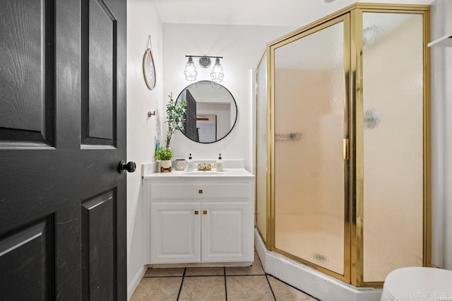 bathroom featuring tile patterned floors, a stall shower, toilet, and vanity