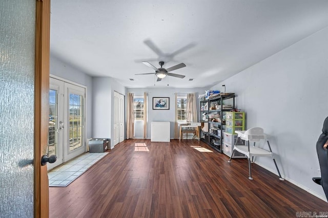 interior space with french doors, a ceiling fan, baseboards, and wood finished floors