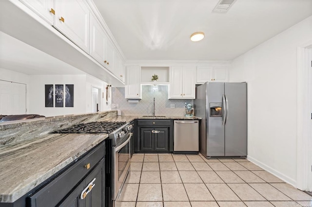 kitchen featuring visible vents, a sink, stainless steel appliances, white cabinets, and backsplash