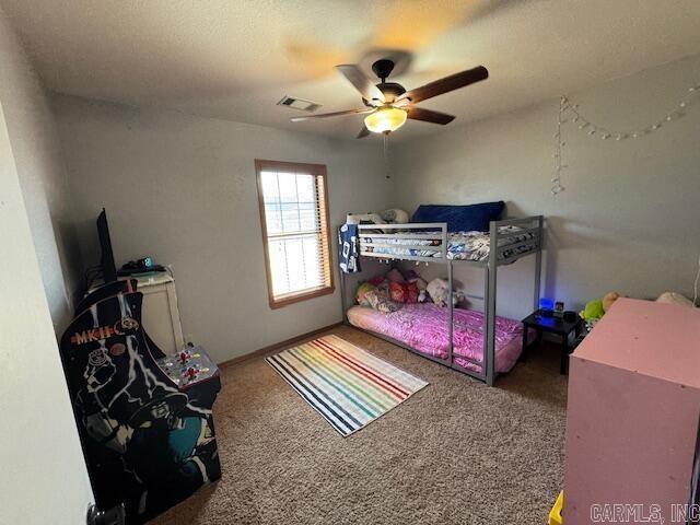 carpeted bedroom with visible vents and ceiling fan