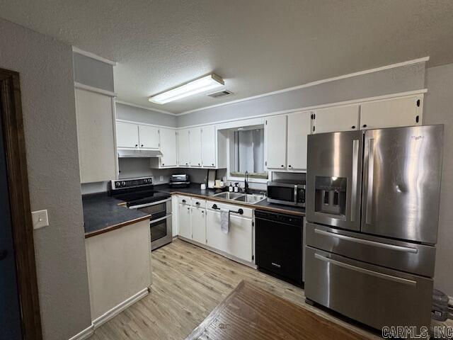 kitchen with visible vents, light wood finished floors, appliances with stainless steel finishes, white cabinetry, and dark countertops