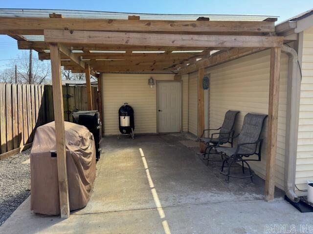 view of patio / terrace with a carport and fence