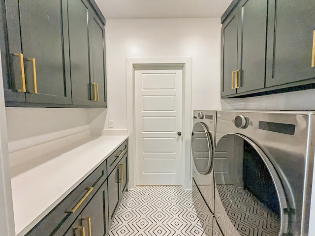 washroom with washing machine and dryer, light tile patterned floors, and cabinet space