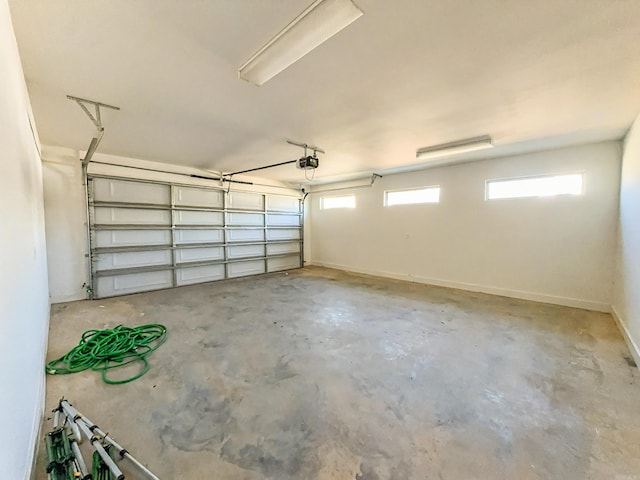 garage featuring a garage door opener and baseboards