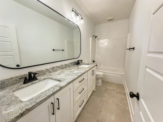 bathroom with a sink, toilet, double vanity, and tile patterned flooring