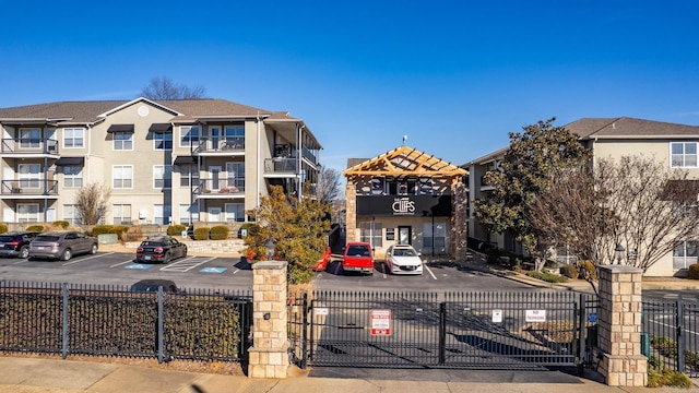 view of building exterior featuring fence and uncovered parking