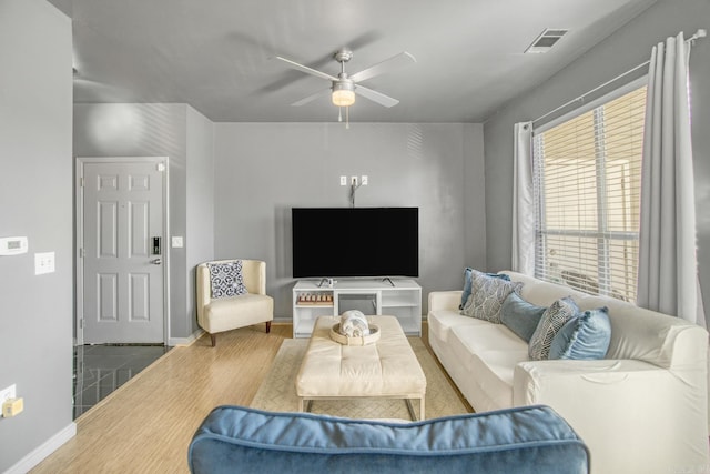 living room with visible vents, ceiling fan, baseboards, and wood finished floors