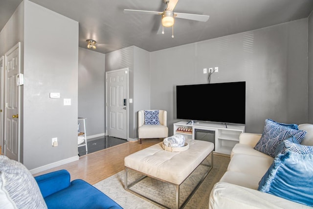 living area featuring ceiling fan, baseboards, and wood finished floors