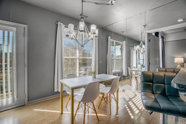 dining area featuring baseboards, wood finished floors, and a chandelier