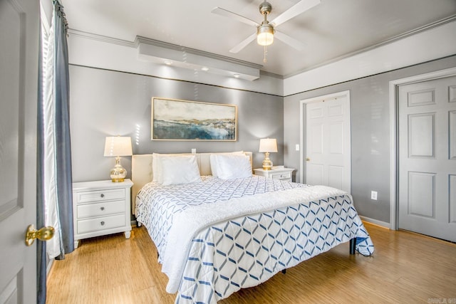 bedroom featuring crown molding, baseboards, light wood-type flooring, and a ceiling fan