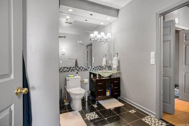 bathroom with baseboards, toilet, vanity, and tile patterned flooring